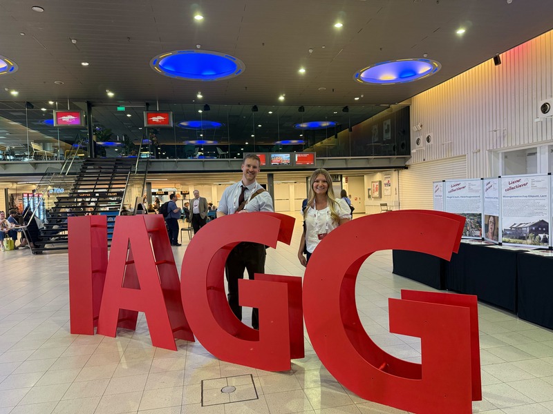 Yoquinto, left, and Warren posing with a large IAGG sign